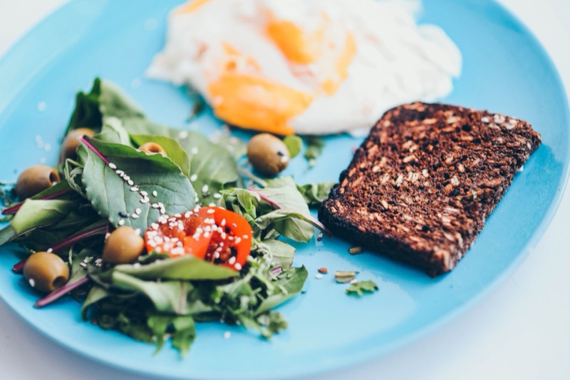 Assiette équilibrée avec œuf, tartine de pain complet et salade