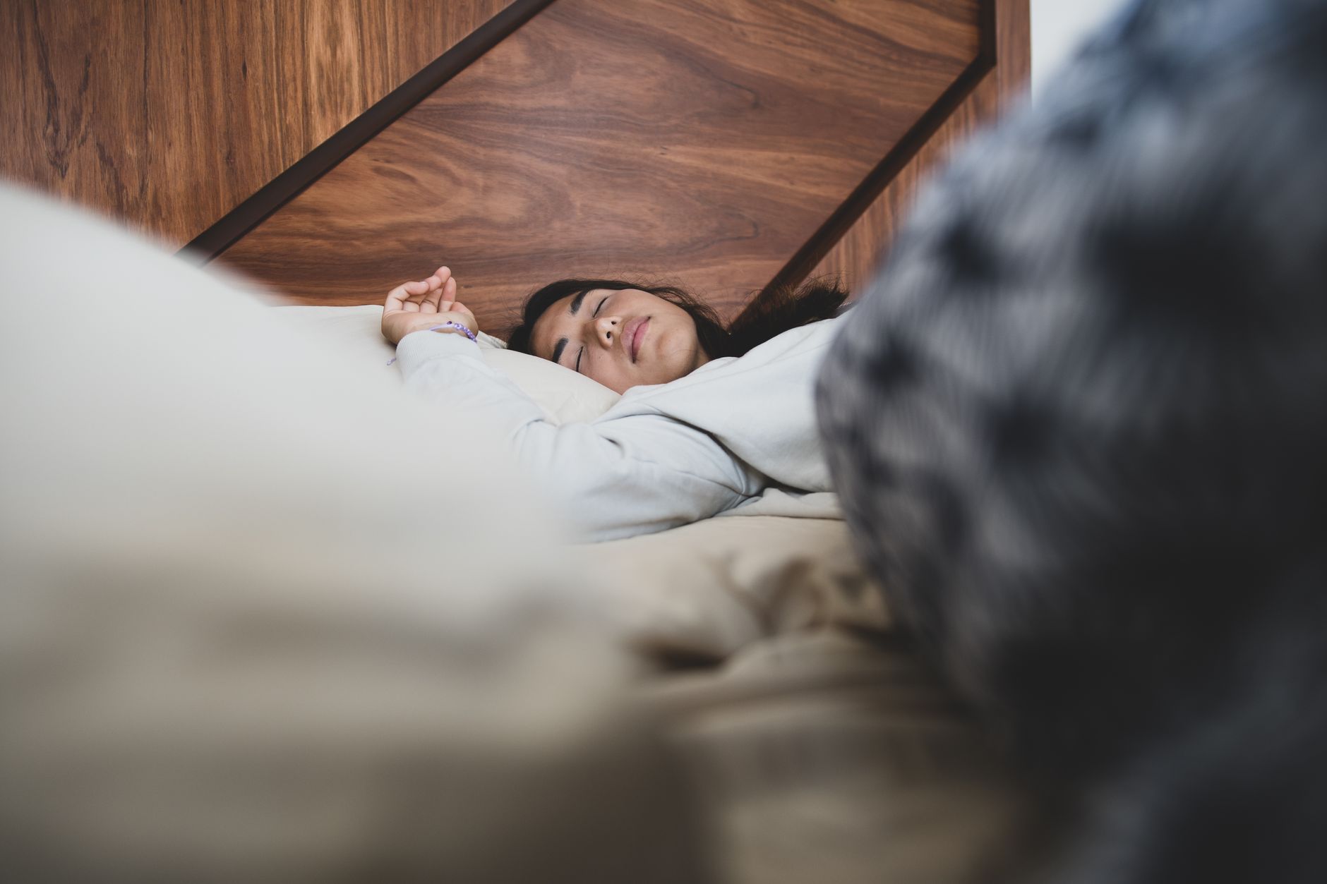 Femme allongée dans un lit douillet, endormie paisiblement dans une chambre chaleureuse